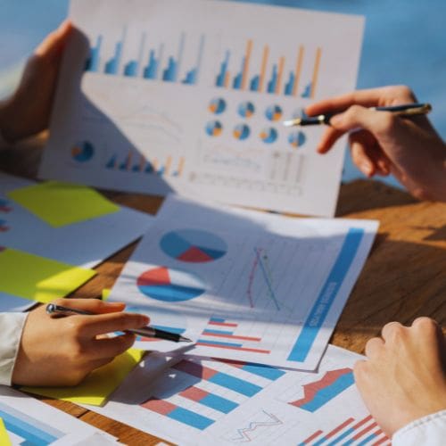 Business professionals analyzing financial charts with downward trends, highlighting shrinking profit margins.
